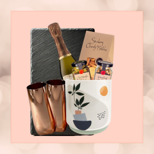 Copper & Clink gift set in an eco-friendly plant pot, featuring a mini bottle of Moët, copper champagne flutes, nibbles, and antipasto, wrapped in sustainable materials."